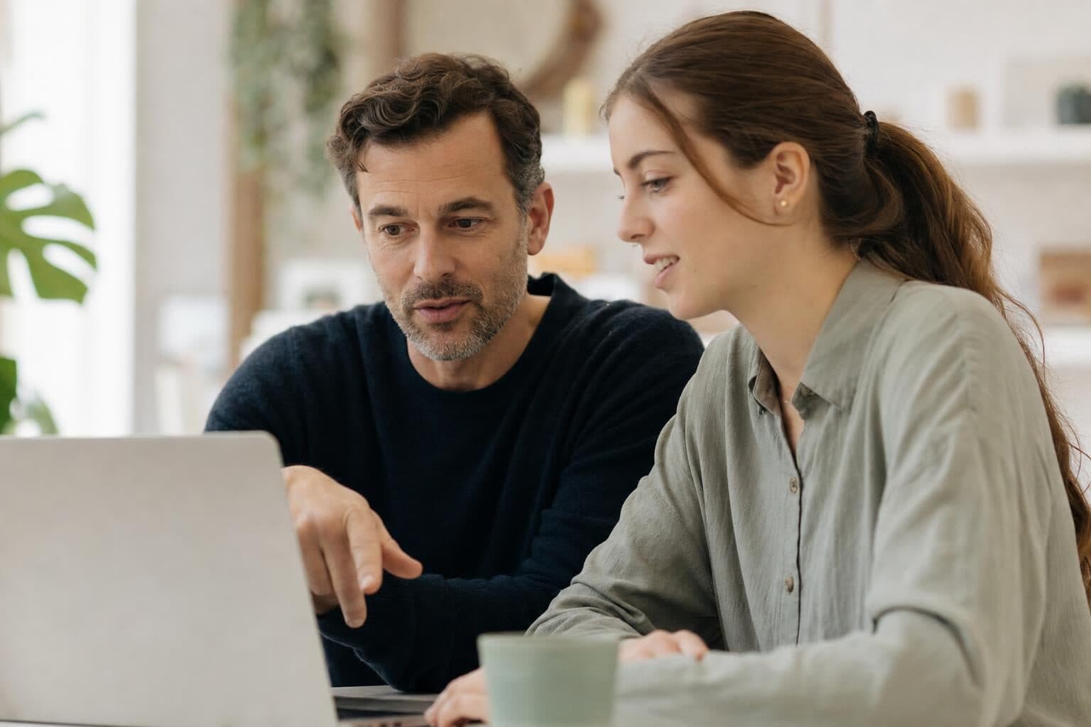 Praxisanleiter und Pflegekraft Seite an Seite am Laptop